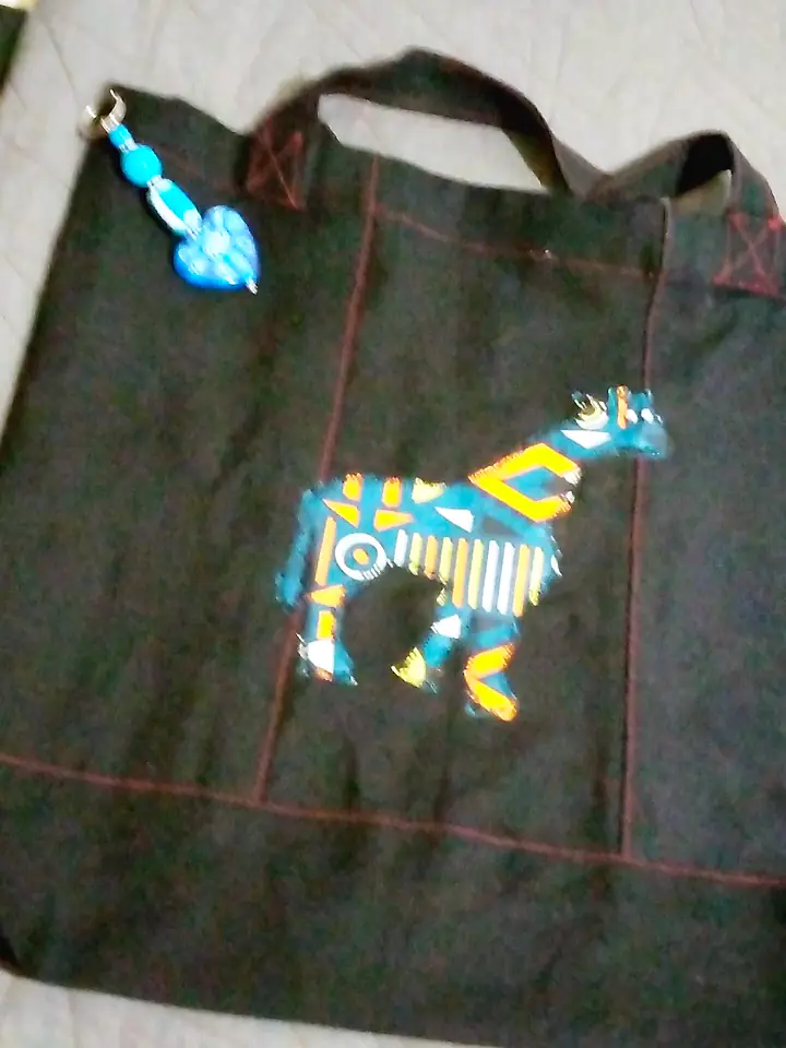 Black canvas tote with a giraffe appliqué in kitenge print and a beaded keyring charm