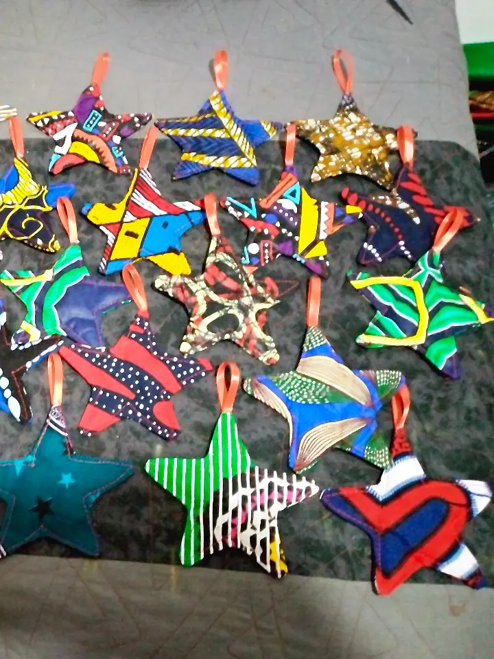 Fabric star ornaments in many kitenge prints, each with a ribbon loop