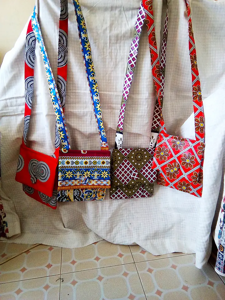 Four crossbody sling bags with long fabric straps in different African prints
