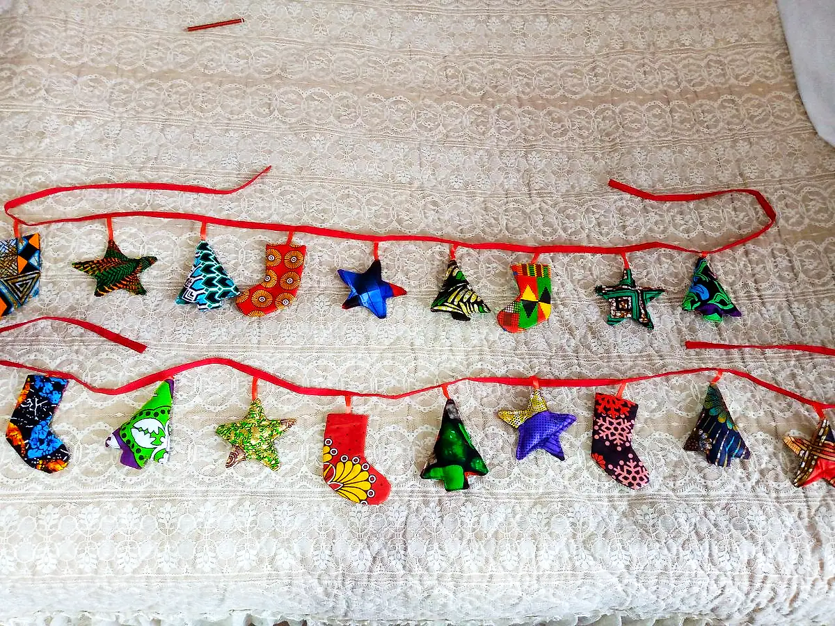 Two garlands of kitenge stars, trees and stockings on red ribbon