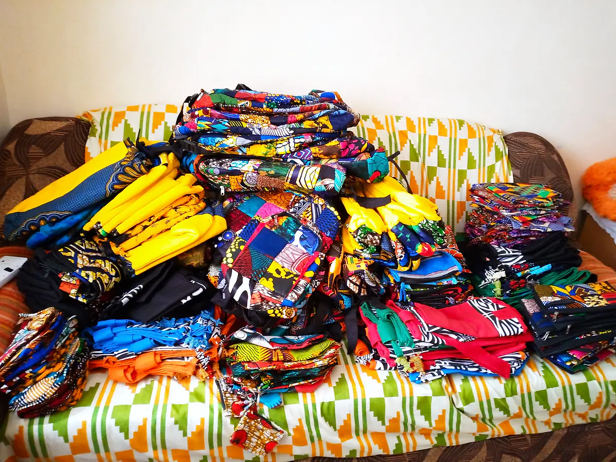 A large pile of finished bags in African prints, ready for an event order