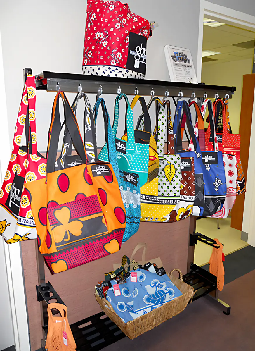 Kanga shopping bags from the Global Bag Project hanging on a display rack