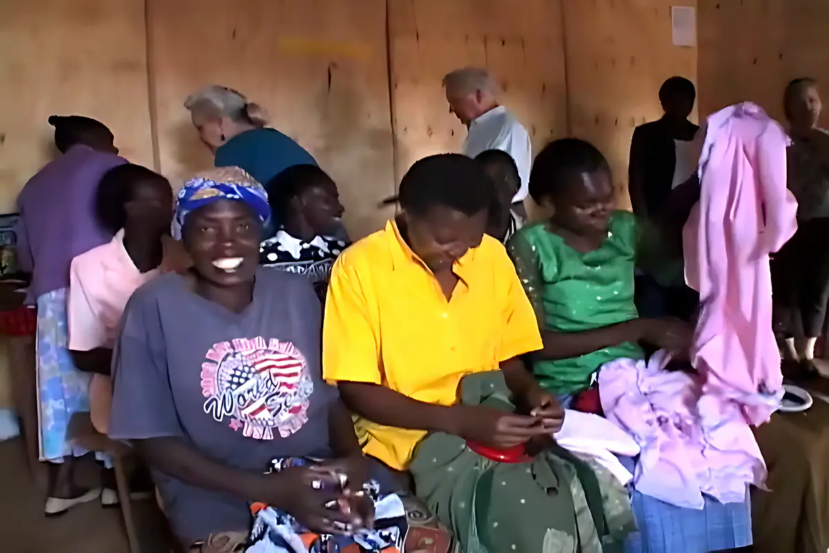 Women smiling together during a sewing training session